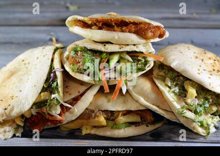 Traditionelle ägyptische beliebte Frühstückssandwiches mit pürierten Fava-Bohnen, gebratenen knusprigen Falafel-Bällen, gebratenen Kartoffeln, Moussaka in Shami-Brot und Stockfoto