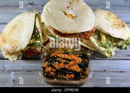 Eingelegte gebratene Aubergine, grüner Pfeffer, traditionelle ägyptische Frühstückssandwiches mit zerdrückten Fava-Bohnen, gebratene knusprige Falafel-Kugeln, gebratene Kartoffeln Stockfoto