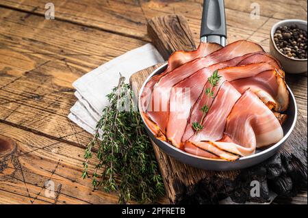 Dünn geschnittener deutscher Schwarzwaldschinken in Pfannkuchen. Holzhintergrund. Draufsicht. Speicherplatz kopieren. Stockfoto