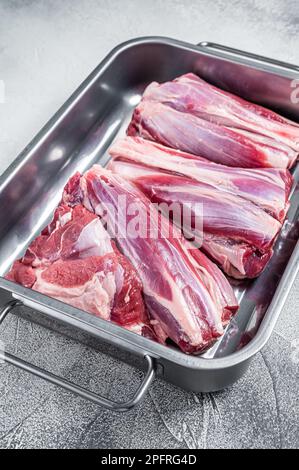 Frisches rohes Lamm legt Fleisch in eine Stahlschale. Weißer Hintergrund. Draufsicht. Stockfoto