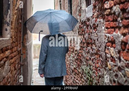 Rückansicht eines Mannes, der im Regen läuft. Stockfoto