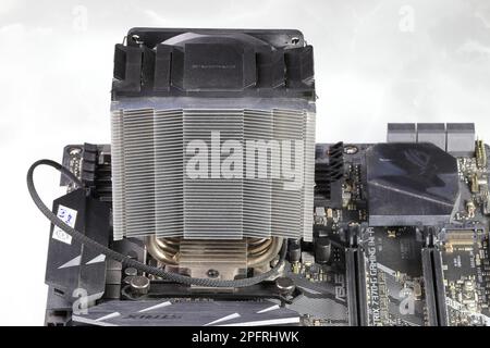 Kühlkörper oder Computerprozessorkühler oder Kühler auf der Hauptplatine des Computers, aktiver CPU-Kühler mit Lüfter, Aluminiumrippe und Wärmerohr auf der Hauptplatine des Computers. Stockfoto