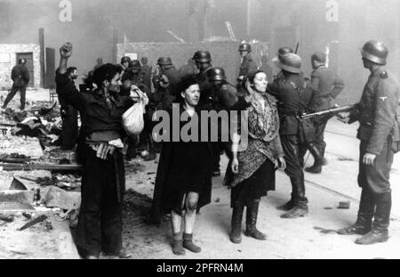 Im Januar 1943 kamen die nazis an, um die Juden des Warschauer Ghettos zu verhaften. Die Juden, die entschlossen waren, es zu bekämpfen, nahmen es mit selbstgemachten und primitiven Waffen auf die SS abgesehen. Die Verteidiger wurden hingerichtet oder deportiert, und das Ghetto-Gebiet wurde systematisch abgerissen. Dieses Ereignis ist bekannt als Ghetto-Aufstand. Dieses Bild zeigt eine Gruppe jüdischer Frauen, die sich mit erhobenen Händen deutschen Soldaten ergeben. Die Frau rechts wurde als Hasia Szylgold-Szpiro benannt. Dieses Bild stammt aus der deutschen Fotoaufzeichnung des Ereignisses, bekannt als Stroop-Bericht. Stockfoto