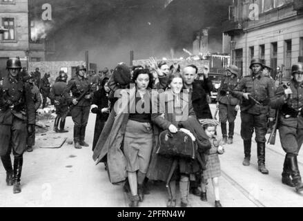 Im Januar 1943 kamen die nazis an, um die Juden des Warschauer Ghettos zu verhaften. Die Juden, die entschlossen waren, es zu bekämpfen, nahmen es mit selbstgemachten und primitiven Waffen auf die SS abgesehen. Die Verteidiger wurden hingerichtet oder deportiert, und das Ghetto-Gebiet wurde systematisch abgerissen. Dieses Ereignis ist bekannt als Ghetto-Aufstand. Dieses Bild zeigt eine Kolonne gefangener Frauen, die die brennende Stadt verlassen. Dieses Bild stammt aus der deutschen Fotoaufzeichnung des Ereignisses, bekannt als Stroop-Bericht. Stockfoto