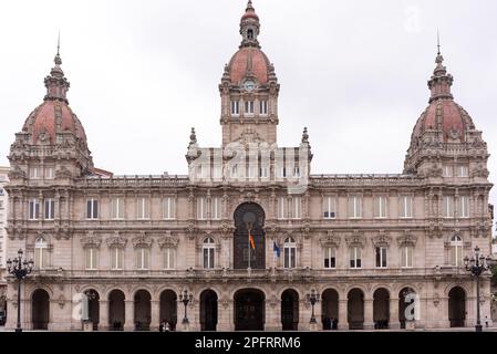 Umgeben von eleganten Gebäuden und Denkmälern, ist das Plaza Maria Pita der perfekte Ort, um sich zu entspannen und die Menschen während des Tages in La Coruña, Galicien, zu beobachten Stockfoto