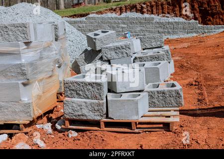 Auf dem neu erbauten Haus wird eine Haltewand auf dem angrenzenden Grundstück gebaut Stockfoto