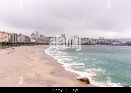 Der weitläufige Sandstrand von La Coruña, Galicien, Spanien, erstreckt sich entlang der Küste und bietet einen atemberaubenden Blick auf den Atlantischen Ozean und die Stadt. Stockfoto