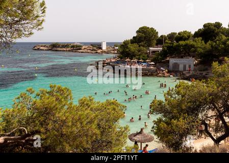 Eingebettet zwischen hohen Klippen bietet die abgeschiedene Cala Deia Bucht in Mallorca, Spanien, kristallklares Wasser und atemberaubende Sicht auf das Mittelmeer Stockfoto