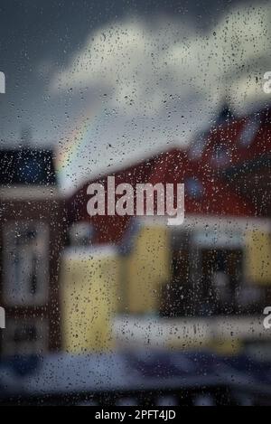 Regentropfen auf einer Fensterscheibe, Fensterregen, verschwommene Stadt, Regen auf Glas. Stockfoto