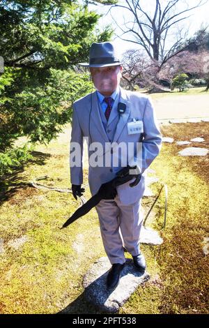 03-26-2015 Kyoto, Japan. Eine Wache mit einem Regenschirm (kann als Stock verwendet werden) in einem leichten Anzug und Hut schließt die Tour des Sento Imperial Estat Stockfoto