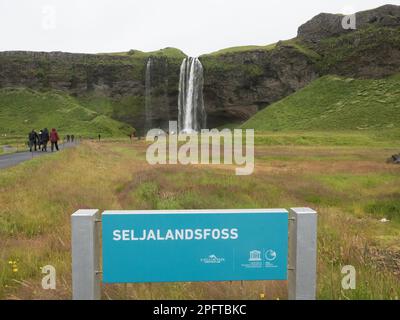 Schild, Touristen auf dem Weg zum Wasserfall, Seljalandsfoss, Abbrecher des Hochlands, Südküste, Island Stockfoto