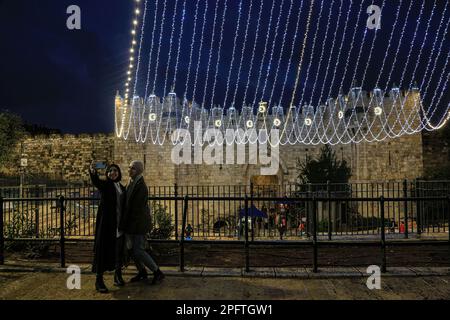 15. März 2023, Ost-Jerusalem, Israel: Die Menschen machen Fotos vor dem Damaskus-Tor, das mit Lichtern dekoriert ist, in Vorbereitung auf den heiligen Monat Ramadan. Der Monat Ramadan gilt als von Moslems getrennt und hat einen Sonderstatus gegenüber den restlichen Monaten des Hijri-Jahres. Es ist der Monat des Fastens, der als eine der Säulen des Islam gilt, in dem Muslime (mit Ausnahme derjenigen, die eine gültige Ausrede haben) auf Essen und Trinken sowie auf eine Gruppe von Verboten verzichten, die das Fasten von morgens an annullieren. Und bis Sonnenuntergang. (Kreditbild: © Saeed Qaq/SOPA Bilder über Z Stockfoto