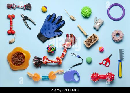 Set aus Tierpflegezubehör, Spielzeug und Trockenfutter auf farbigem Hintergrund Stockfoto