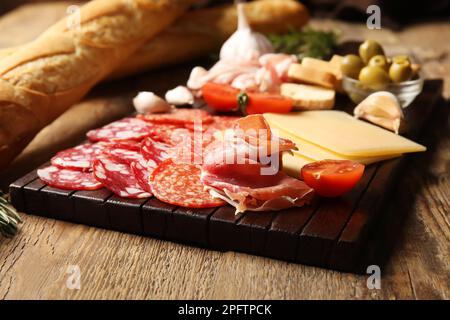 Gehen Sie an Bord mit einer Auswahl an leckeren Fleischgerichten und Käse auf Holzhintergrund Stockfoto