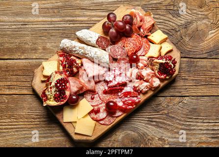 Gehen Sie an Bord mit einer Auswahl an leckeren Delikatessen auf Holzhintergrund Stockfoto