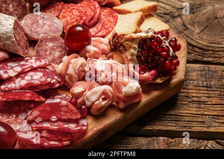 Boarding mit einer Auswahl an leckeren Fleischgerichten auf Holzhintergrund, Nahaufnahme Stockfoto