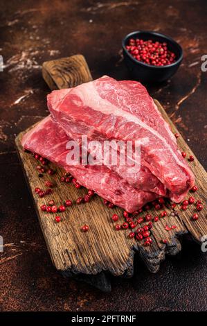 Rohes Filet-Rindfleisch, Silverside-Steak auf einem Holzbrett. Dunkler Hintergrund. Draufsicht. Stockfoto