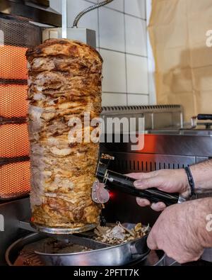 Saftige griechische, traditionelle Gyros, gegrillt und mit einem Messer gehackt Stockfoto