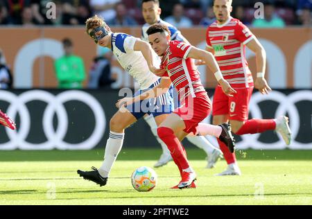 Deutschland. 18. März 2023. Augsburg, Deutschland. 18. März 2023. firo : 03/18/2023, Fußball, 1. Liga, 1. Bundesliga, Staffel 2022/2023, 25. Spieltag FC Augsburg - FC Schalke 04 1: 1, Cedric Brunner, FC Schalke 04, S04, Schalke, Ruben Vargas, FC Augsburg, FCA, Augsburg, vollständige Figur, Duels, Kredit: dpa/Alamy Live News Kredit: dpa Picture Alliance/Alamy Live News Stockfoto