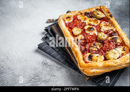 Vegetarische Blätterteigpizza mit Artischocke, Mozzarella, Tomaten und Käse. Weißer Hintergrund. Draufsicht. Speicherplatz kopieren. Stockfoto