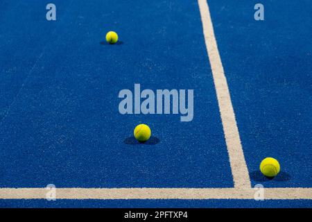 Drei Bälle auf der Oberfläche eines blauen Paddle-Tennisplatzes Stockfoto