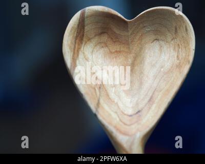 Nahaufnahme eines handgeschnitzten hölzernen Löffels in Herzform Stockfoto