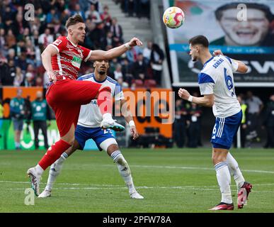 Augsburg, Deutschland. 18. März 2023. Ermedin Demirovic (Front L) aus Augsburg spielt mit Tom Krauss (Front R) der Schalke 04 während des deutschen Bundesliga-Fußballspiels in der ersten Liga zwischen dem FC Augsburg und dem FC Schalke 04 in Augsburg, Deutschland, 18. März 2023. Kredit: Philippe Ruiz/Xinhua/Alamy Live News Stockfoto