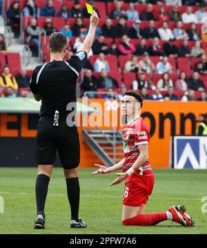 Augsburg, Deutschland. 18. März 2023. Der Schiedsrichter zeigt Ruben Vargas (R) aus Augsburg eine gelbe Karte während des deutschen Bundesliga-Fußballspiels in der ersten Liga zwischen dem FC Augsburg und dem FC Schalke 04 in Augsburg, Deutschland, am 18. März 2023. Kredit: Philippe Ruiz/Xinhua/Alamy Live News Stockfoto