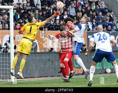 Augsburg, Deutschland. 18. März 2023. Augsburgs Torwart Rafal Gikiewicz (1. l) rettet den Ball während des deutschen Bundesliga-Fußballspiels in der ersten Liga zwischen dem FC Augsburg und dem FC Schalke 04 in Augsburg, Deutschland, am 18. März 2023. Kredit: Philippe Ruiz/Xinhua/Alamy Live News Stockfoto