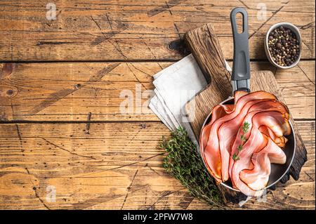 Dünn geschnittener deutscher Schwarzwaldschinken in Pfannkuchen. Holzhintergrund. Draufsicht. Speicherplatz kopieren. Stockfoto