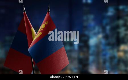 Kleine Flaggen der Mongolei auf abstraktem, verschwommenem Hintergrund. Stockfoto
