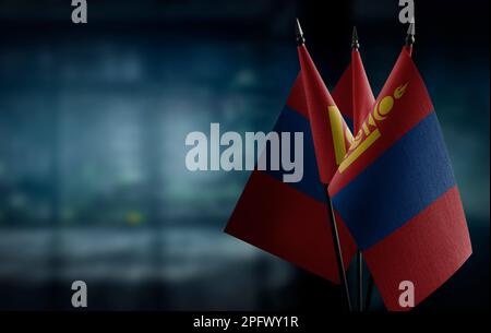 Kleine Flaggen der Mongolei auf abstraktem, verschwommenem Hintergrund. Stockfoto