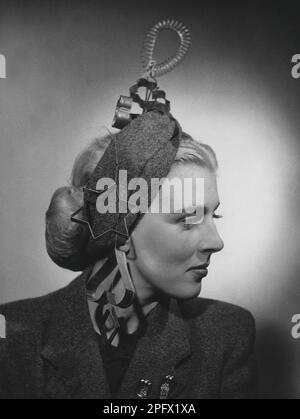 Hut-Mode in den 1940er. Eine junge blonde Frau zeigt als Teil der Kreation ein kreatives Kopfstück mit einer Backform in verschiedenen Formen. Schweden 1942 Kristoffersson Stockfoto