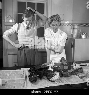 Schuhe in den 1940er. Ein Paar mit Schuhen vor ihnen auf dem Küchentisch. Die Schuhe werden einige Zeit benutzt und müssen poliert werden. Schweden 1943 Kristoffersson Ref D59-1 Stockfoto