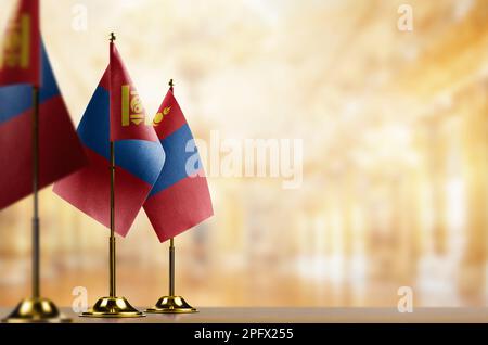 Kleine Flaggen der Mongolei auf abstraktem, verschwommenem Hintergrund. Stockfoto
