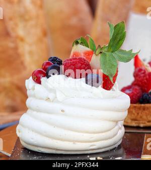 Pavlova Dessert mit Sommerbeeren, Obst, Himbeeren, Erdbeeren, Heidelbeeren und Johannisbeeren. Nahaufnahme des Desserts am Stand von Prag Stockfoto