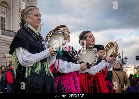 Madrid, Spanien. 18. März 2023. Eine Gruppe von Frauen in regionalen Kostümen aus Nordspanien spielen ihre Tamburinen, während sie vor dem Königlichen Palast in Madrid parieren. Dudelsackspieler haben anlässlich der Festlichkeiten von San Patricio durch das Zentrum von Madrid gezogen. In diesem Jahr hat sich die spanische Hauptstadt zum ersten Mal der irischen Tradition von ihrer Hauptstadt Dublin aus angeschlossen und hat sich auf große Städte in der ganzen Welt, einschließlich New York, ausgebreitet. Kredit: SOPA Images Limited/Alamy Live News Stockfoto