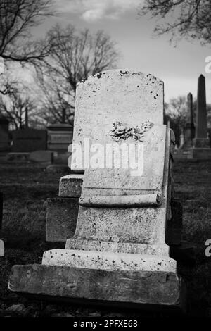 Abgenutzter und verwitterter alter Grabstein mit einer leeren Epitaphe und Platz für Text. Stockfoto