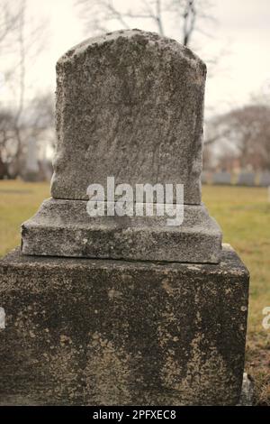 Abgenutzter und verwitterter alter Grabstein mit einer leeren Epitaphe und Platz für Text. Stockfoto