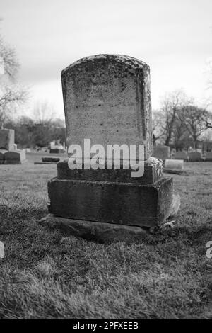 Abgenutzter und verwitterter alter Grabstein mit einer leeren Epitaphe und Platz für Text. Stockfoto