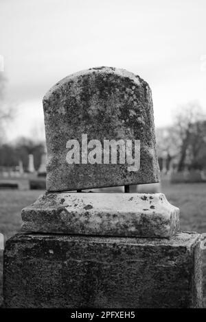 Abgenutzter und verwitterter alter Grabstein mit einer leeren Epitaphe und Platz für Text. Stockfoto