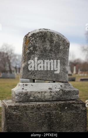 Abgenutzter und verwitterter alter Grabstein mit einer leeren Epitaphe und Platz für Text. Stockfoto