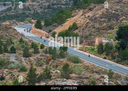 Mehrere Motorräder, die auf einer Zweibahnstraße umherfahren und eine Kurve in den Bergen haben. Stockfoto