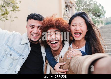 Nahaufnahme eines Porträts einer Gruppe glücklicher Jugendfreunde, die lachen und Spaß beim Fotografieren haben. Junge, multiethnische Menschen, die lächeln und draußen vor der Kamera stehen. Freundschaftskonzept. Hochwertiges Foto Stockfoto