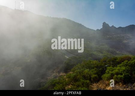 Nebel im grünen Teno-Gebirge bei Masca mit Serpentinenstraßen auf der Kanarischen Insel Teneriffa, Spanien Stockfoto