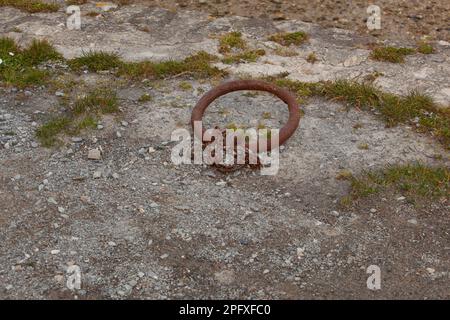 Auf dem Boden befindet sich ein Anlegering, der von grünem Gras und Kieseln umgeben ist. Stockfoto