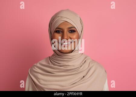 Porträt Einer Wunderschönen Jungen Muslimischen Frau In Hijab, Die Über Dem Rosa Hintergrund Posiert Stockfoto