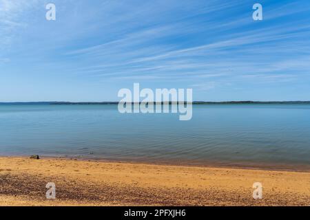 Blick von Redland Bay über das ruhige Wasser zu den südlichen Moreton Bay Inseln am Horizont, unter einem wunderschönen blauen Himmel mit Cirrostratuswolken Stockfoto