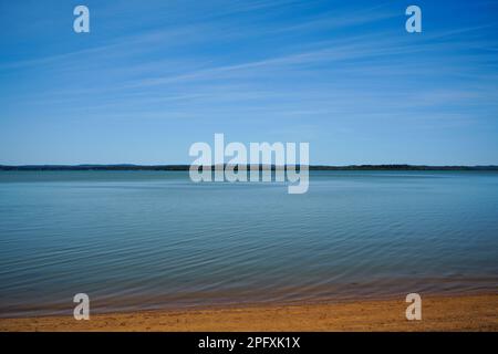 Blick von Redland Bay über das ruhige Wasser zu den südlichen Moreton Bay Inseln am Horizont, unter einem wunderschönen blauen Himmel mit Cirrostratuswolken Stockfoto