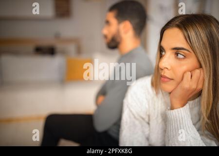 Traurig beleidigtes internationales Millennials-Paar Denken Sie an Scheidung nach Streit im Wohnzimmer, nah dran Stockfoto